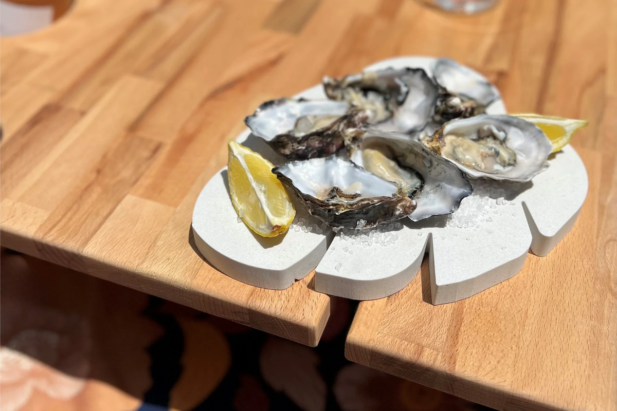 Caesarstone Midday Outdoor UV resistant. Monstera leaf shaped platter with freshly shucked oysters. Summer fruits.