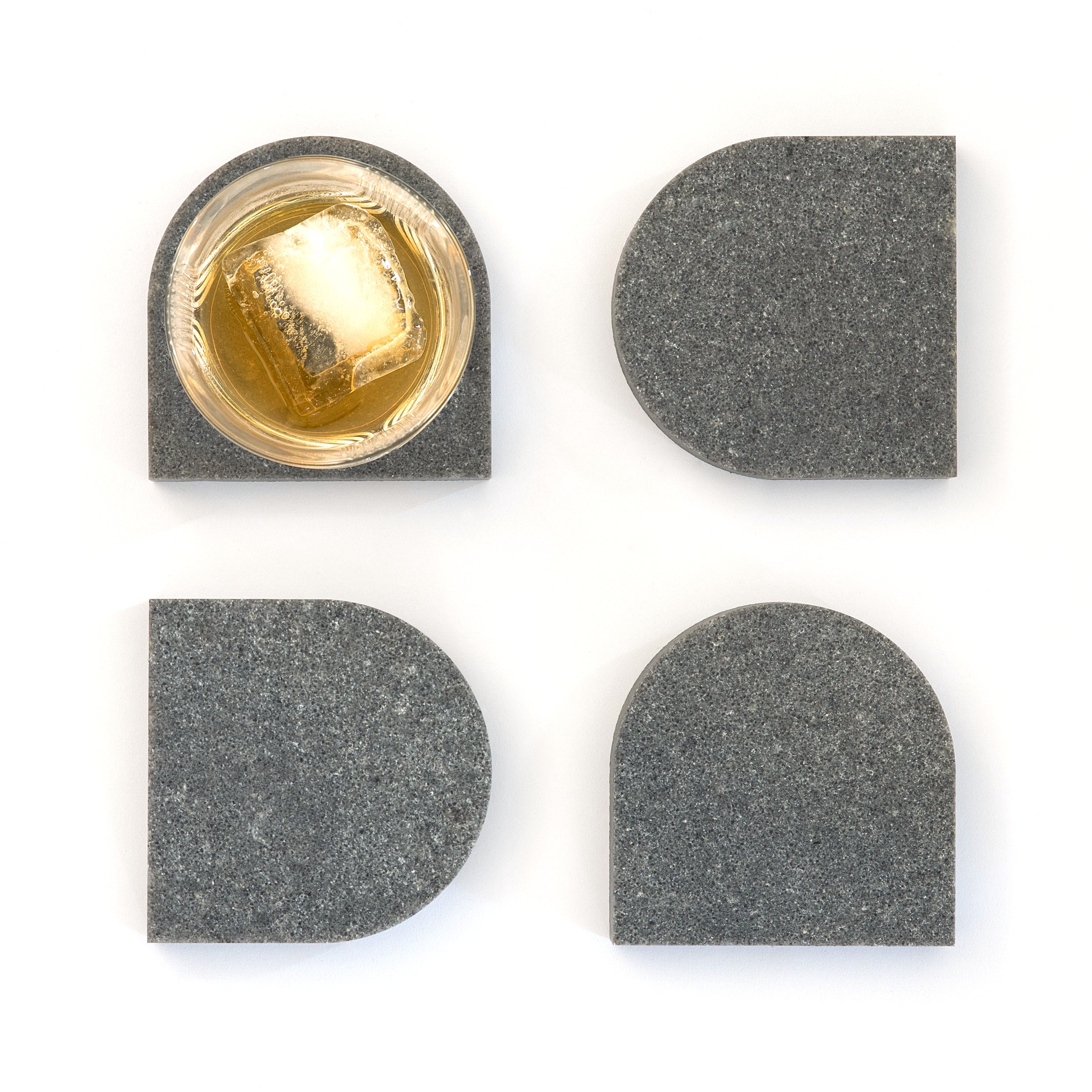 Quartz Arch Coaster™ Set 4 Piece in Rugged Concrete™. Quartz Rugged Concrete™ stone coasters in an arch shape. These dark grey quartz coasters have a cork backing. white and grey marble coasters in appearance however quartz has greater scratch resistance and is lower maintenance. caesarstone quartz