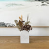 Arch Vase used to display dried or fresh flowers, a timeless display piece. Shown with natural toned posy. Crafted from durable stone, evoking a luxurious contemporary feel. Available in Cloudburst Concrete by Caesarstone - soft swells of pure white that veil a solid, creamy base, for an infinitely beautiful surface. An ideal decorative accent.