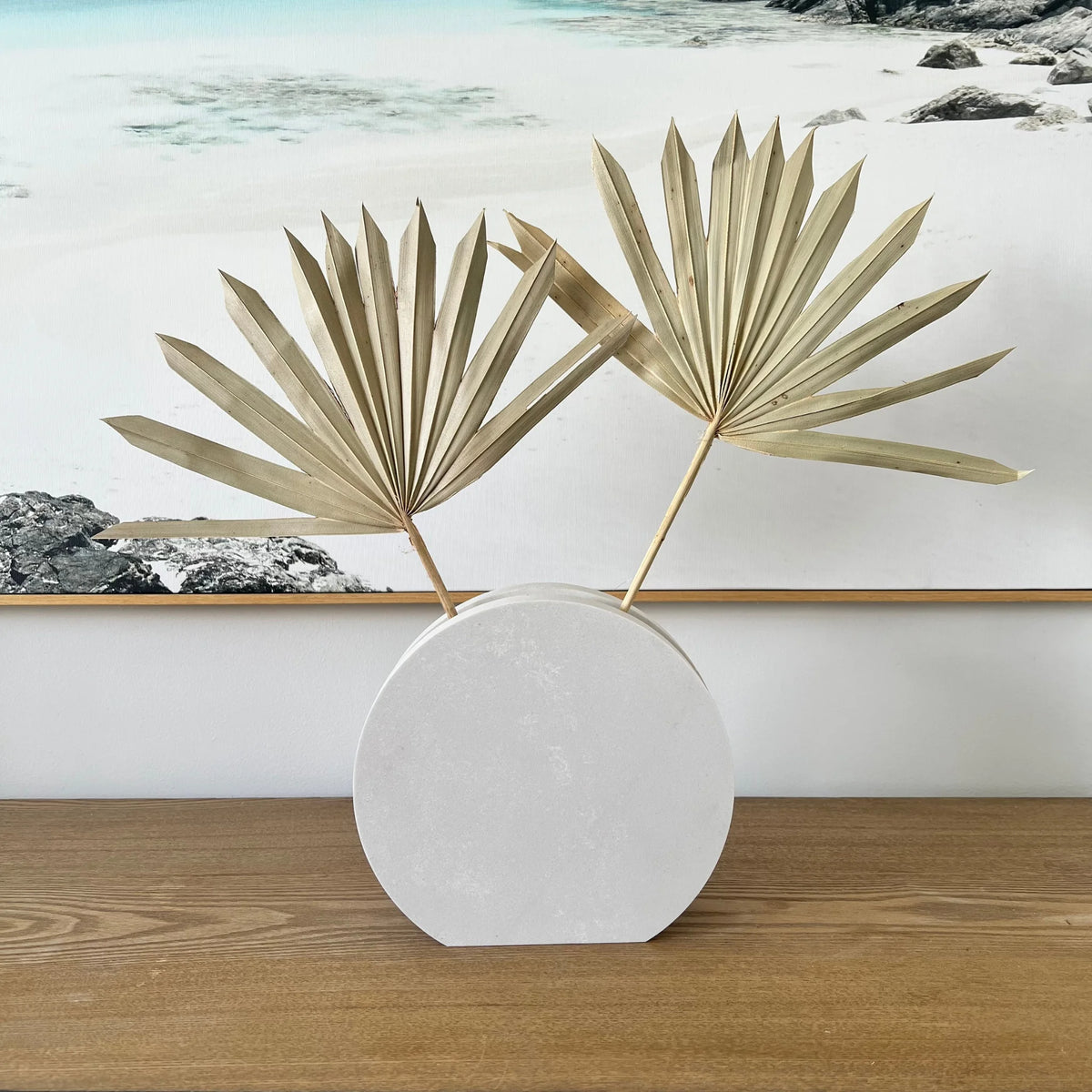 Image of Round Vase used to display dried palm leaves, a timeless display piece. Crafted from durable stone, evoking a luxurious contemporary feel. Available in Cloudburst Concrete by Caesarstone - soft swells of pure white that veil a solid, creamy base, for an infinitely beautiful surface. An ideal decorative accent.