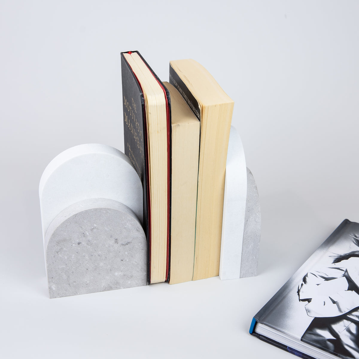 Quartz Bookend Set is 4cm thick. Styled with books. Available in Clamshell partnered with Organic White by Caesarstone  a beautiful fusion of light grey with white features, underscored by drifting veins on a neutral base, meets a clean white surface with subtly blended undertones, reflecting a natural appearance that is effortlessly chic. The perfect addition to your home decor, similar to marble bookends.