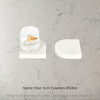 Two Caesarstone Alpine Mist arch stone coasters on a marble surface with text 'Alpine Mist Arch Coasters 10x2cm'.
