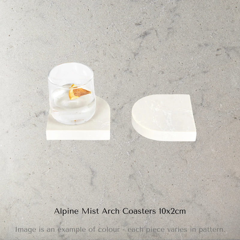 Two Caesarstone Alpine Mist arch stone coasters on a marble surface with text 'Alpine Mist Arch Coasters 10x2cm'.
