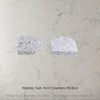 Two Caesarstone Atlantic Salt Arch Coasters on a concrete surface with text 'Atlantic Salt Arch Coasters 10x2cm'.