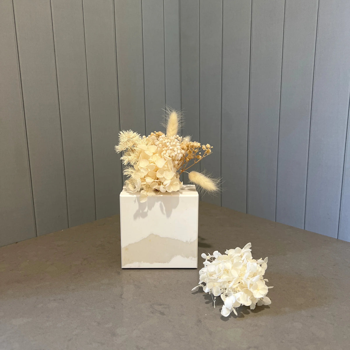 Solid marble like mini stone vase in Caesarstone Calacutta Maximus with mini dried flower posy. This is the gift to buy when you think what to buy from someone that has everything.