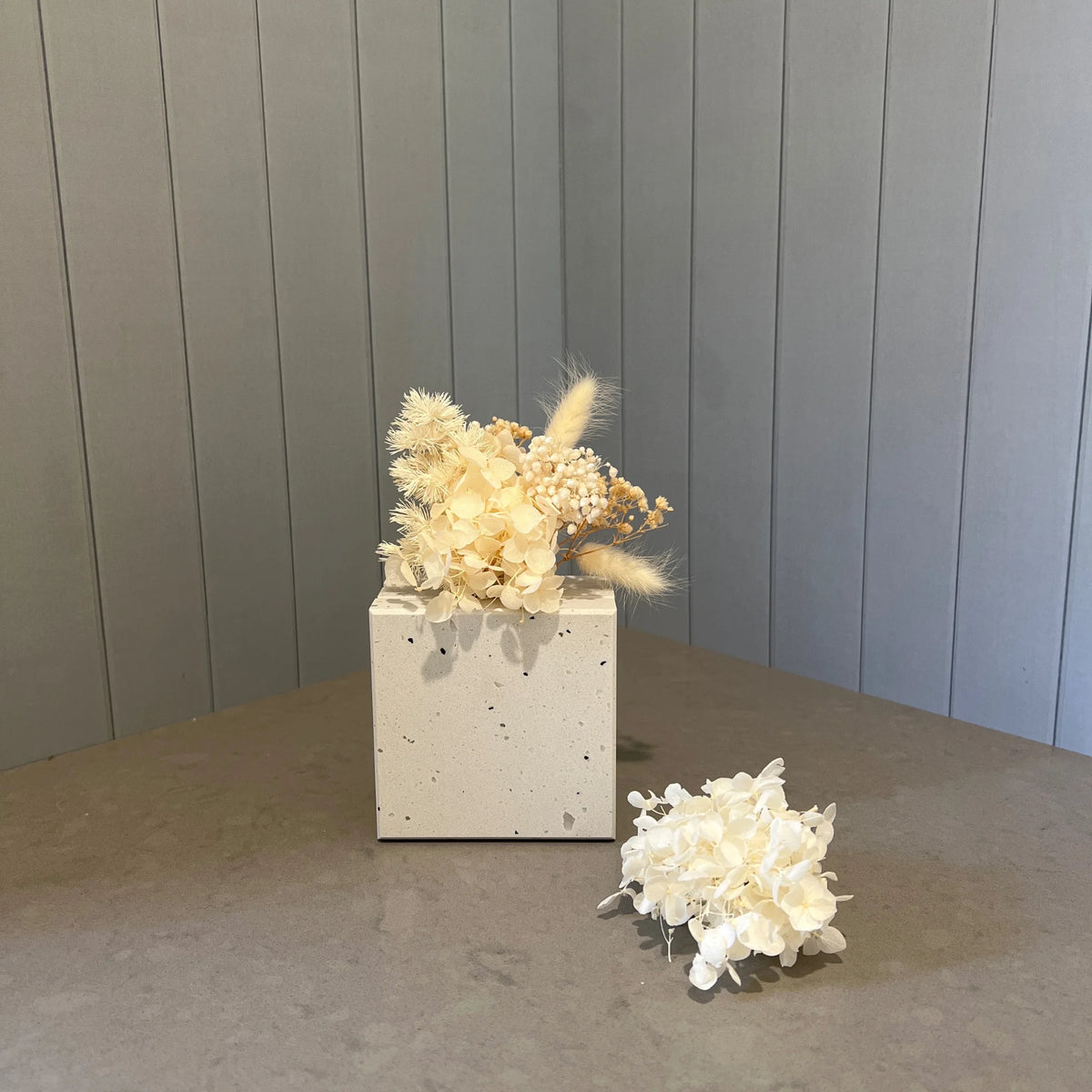 Solid terrazzo look mini stone vase in Caesarstone Frozen Terra with mini dried flower posy. This is the gift to buy when you think what to buy for someone that has everything.