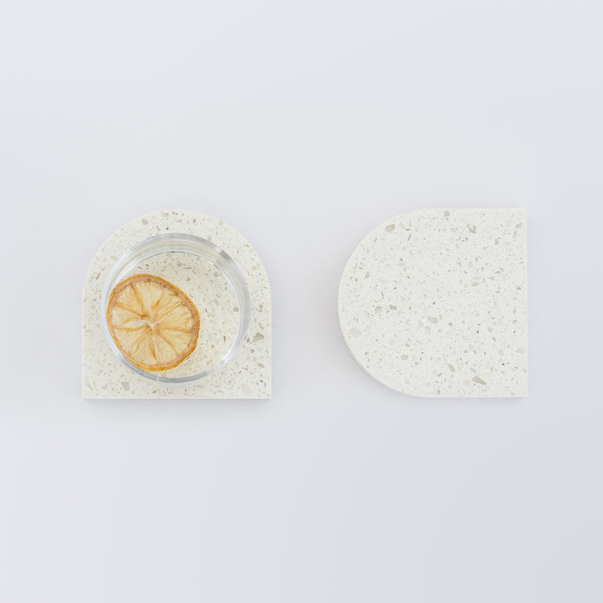 Quartz Arch Coaster™ 2 Piece in Nougat™. Quartz white stone coasters in an arch shape. These white quartz coasters are specked with decorative quartz with a cork backing. White marble coasters in appearance however quartz has greater scratch resistance and is lower maintenance. caesarstone.