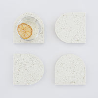 Quartz Arch Coaster™ Set 4 Piece in Nougat™. Quartz white stone coasters in an arch shape. These white quartz coasters are specked with decorative quartz with a cork backing. White marble coasters in appearance however quartz has greater scratch resistance and is lower maintenance. caesarstone quartz