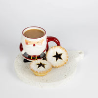 Santa-themed mug with a drink and mince pies on a stone surface, Christmas Decoration shaped large coaster.