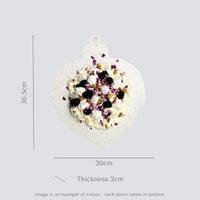 Teardrop-shaped ornament with pavlova and measurements on a gray background