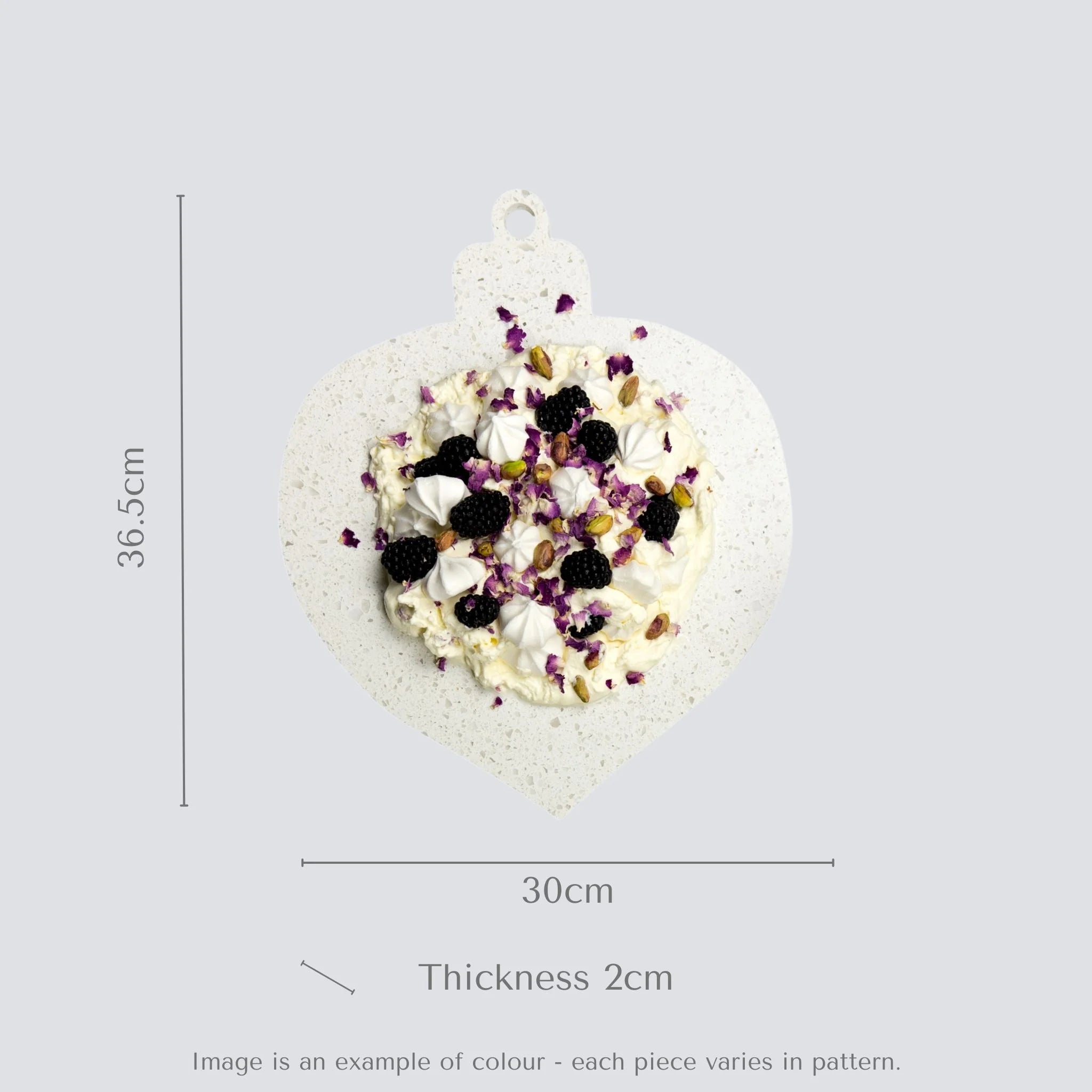 Teardrop-shaped ornament with pavlova and measurements on a gray background