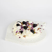 Teardrop ornament-shaped dessert platter with blackberries and cream on a light gray background